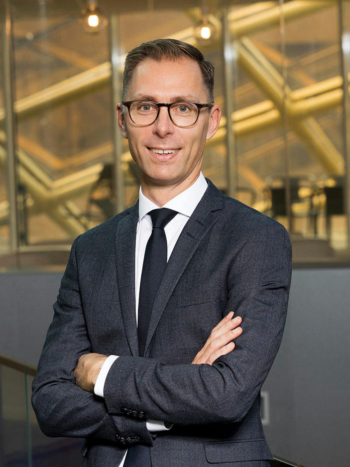 Martin Richardson in suit, smiling.